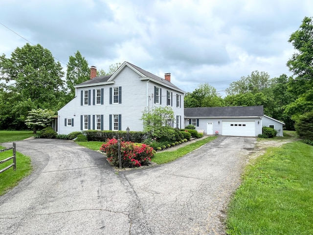 colonial house with a garage and a front lawn