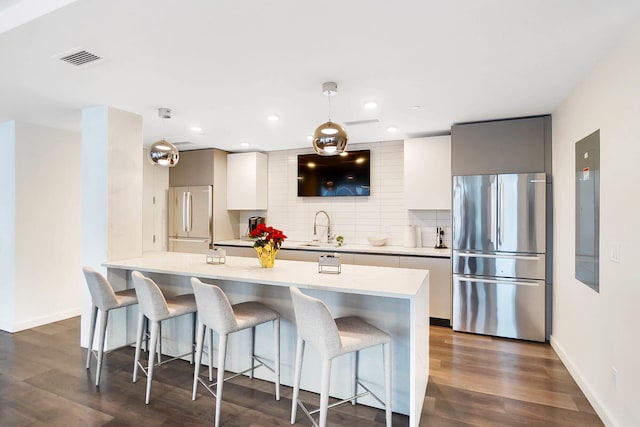 kitchen with pendant lighting, stainless steel fridge, and dark hardwood / wood-style flooring