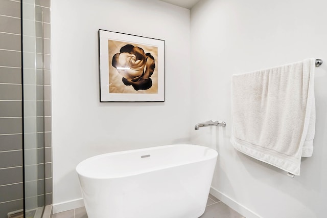 bathroom with a tub to relax in and tile patterned floors