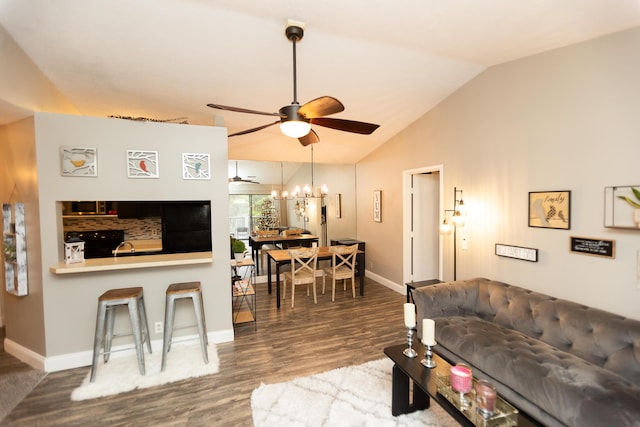 living room with a notable chandelier, vaulted ceiling, and hardwood / wood-style flooring