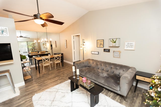 living room with hardwood / wood-style flooring, ceiling fan with notable chandelier, and vaulted ceiling