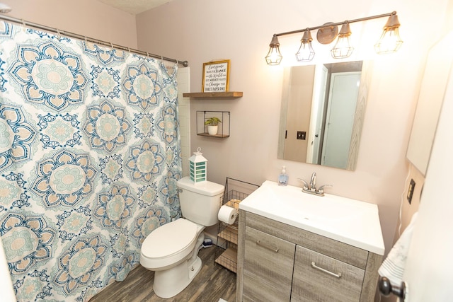 bathroom with hardwood / wood-style flooring, vanity, toilet, and walk in shower