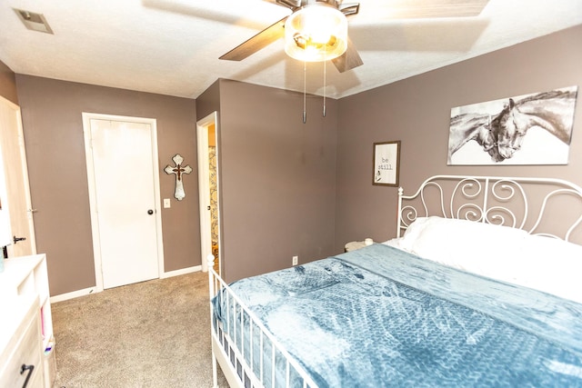 carpeted bedroom with ceiling fan and a textured ceiling