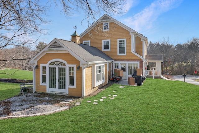 back of house featuring a yard and french doors