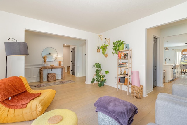 living room with sink and light wood-type flooring