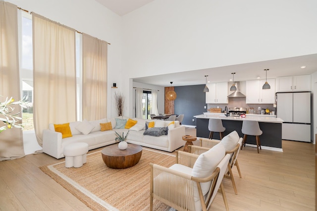 living room featuring light wood-type flooring and a high ceiling