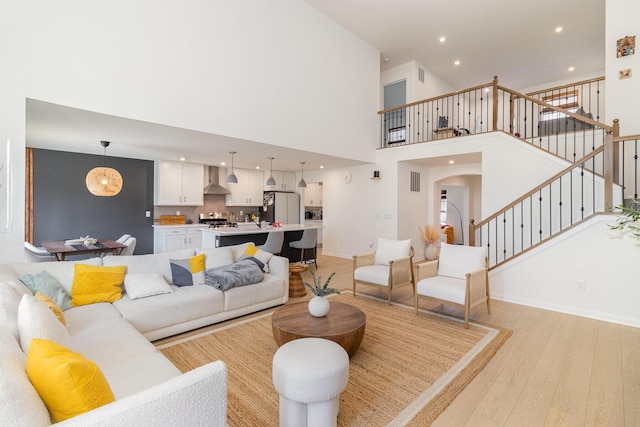 living room with light wood-type flooring and a high ceiling