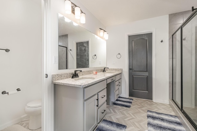 bathroom featuring an enclosed shower, vanity, toilet, and parquet floors