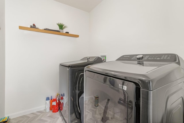 laundry room with washer and clothes dryer and light parquet flooring