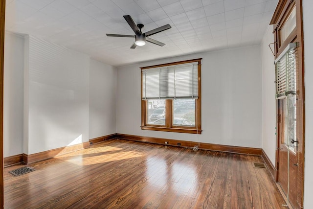 spare room featuring a ceiling fan, wood finished floors, visible vents, and baseboards