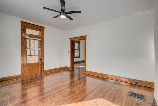 spare room featuring ornamental molding, wood finished floors, visible vents, and baseboards