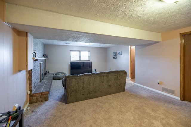 living room featuring a textured ceiling, carpet floors, and a brick fireplace