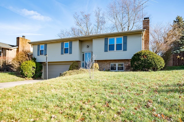 bi-level home featuring a garage and a front lawn