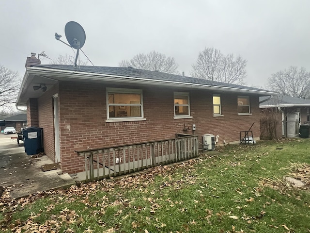 view of side of home featuring a lawn and central air condition unit