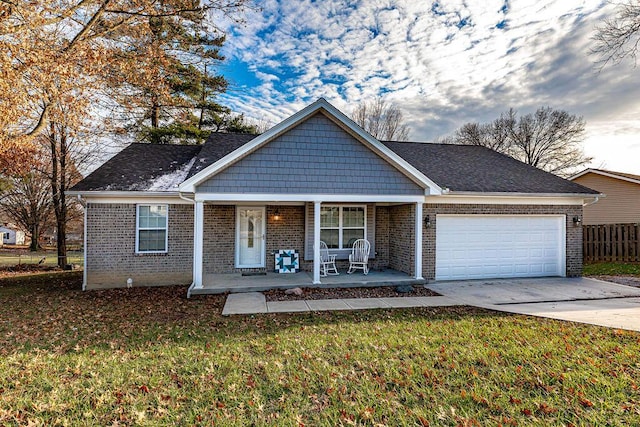 view of front of house featuring covered porch, a garage, and a front lawn