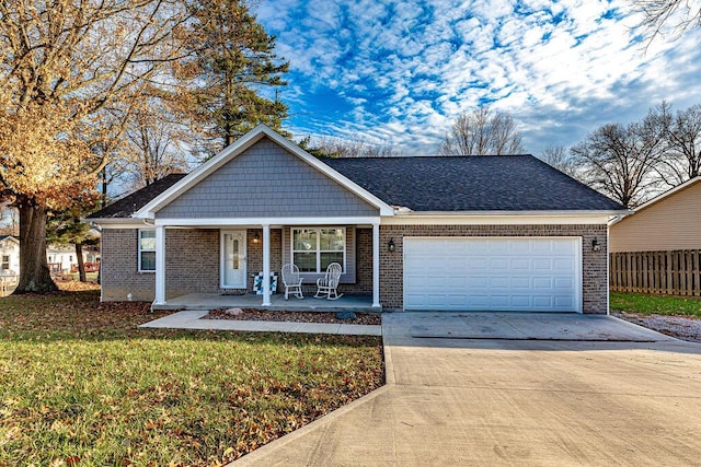 view of front facade featuring a porch, a garage, and a front lawn