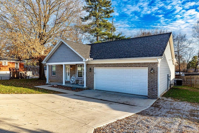 view of front of house featuring covered porch, central AC unit, and a garage