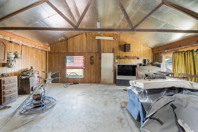 misc room with wooden walls, electric panel, and lofted ceiling