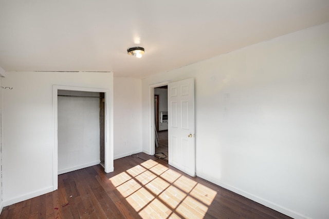 unfurnished bedroom featuring a closet and dark wood-type flooring