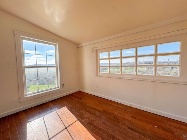 empty room with dark wood-type flooring and vaulted ceiling