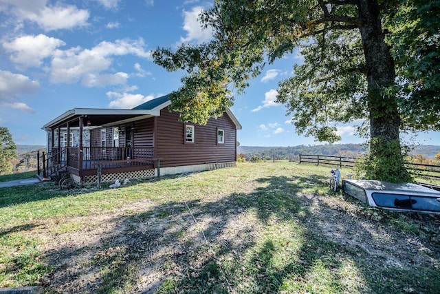 view of side of property with a lawn and a rural view