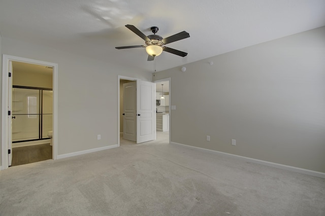 unfurnished bedroom with light colored carpet, ensuite bath, and ceiling fan