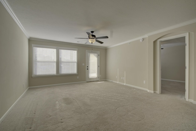 carpeted spare room with ceiling fan and ornamental molding