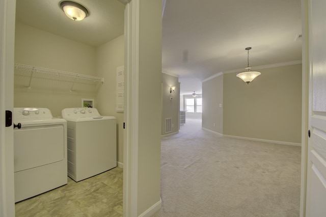 clothes washing area with light carpet, washer and dryer, and ornamental molding