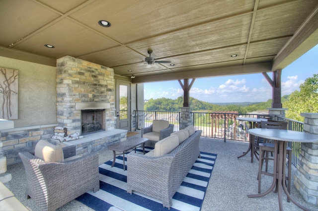 view of patio / terrace with an outdoor living space with a fireplace, ceiling fan, and a mountain view