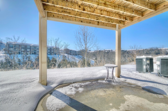 snow covered patio with central AC unit