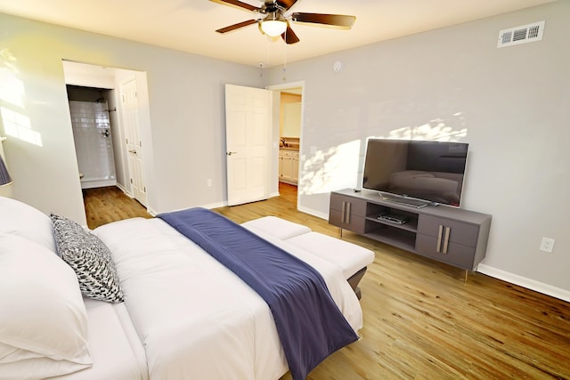 bedroom with hardwood / wood-style floors, ensuite bath, and ceiling fan