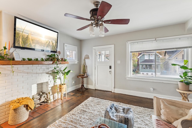 entrance foyer with a fireplace, ceiling fan, and dark wood-type flooring