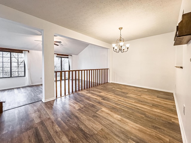 empty room featuring a textured ceiling, a healthy amount of sunlight, and vaulted ceiling