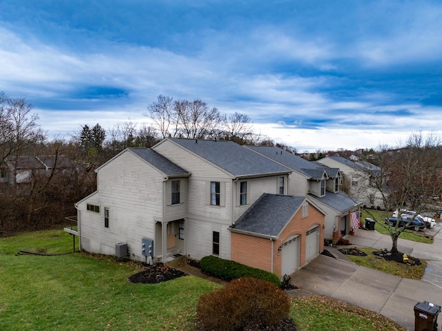 view of front of property with central air condition unit, a front lawn, and a garage