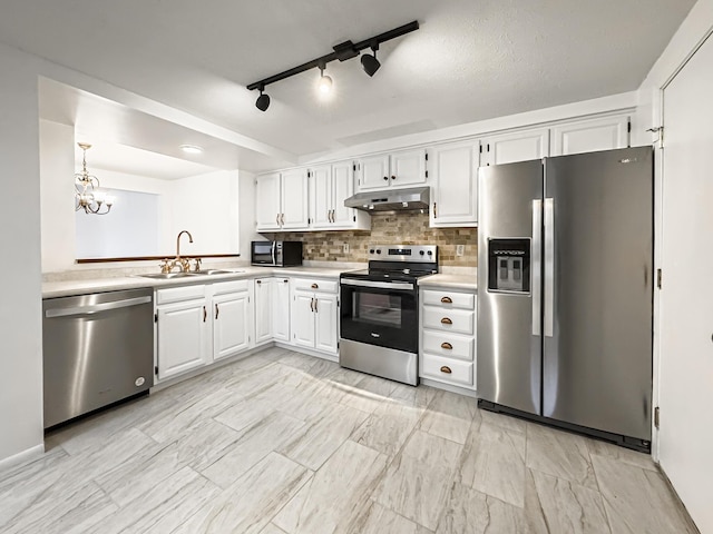 kitchen featuring sink, hanging light fixtures, decorative backsplash, appliances with stainless steel finishes, and white cabinetry