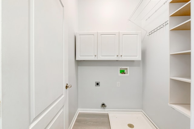 laundry area featuring hookup for an electric dryer, washer hookup, light wood-type flooring, and cabinets