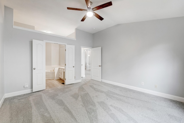 unfurnished bedroom featuring light carpet, connected bathroom, ceiling fan, and lofted ceiling