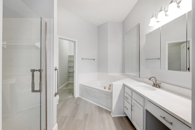 bathroom with hardwood / wood-style flooring, vanity, and independent shower and bath