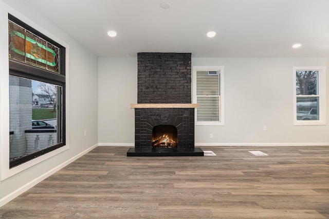 unfurnished living room featuring a fireplace and hardwood / wood-style flooring