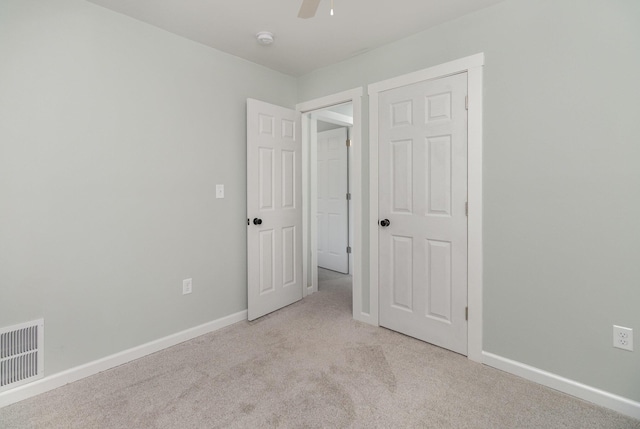 unfurnished bedroom with light colored carpet and ceiling fan