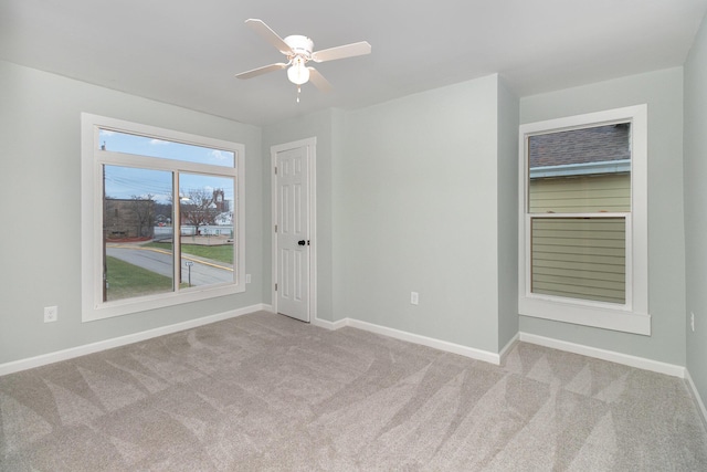 spare room featuring ceiling fan and light colored carpet