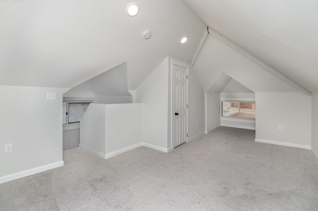 additional living space with light colored carpet and vaulted ceiling