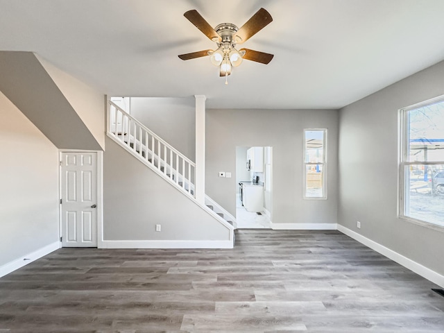 unfurnished living room with ceiling fan and dark hardwood / wood-style floors