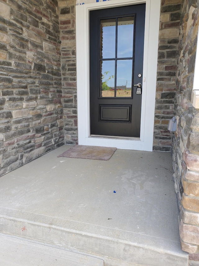 view of exterior entry with brick siding and stone siding