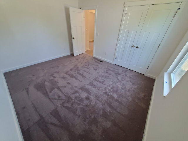 unfurnished bedroom featuring carpet floors and baseboards