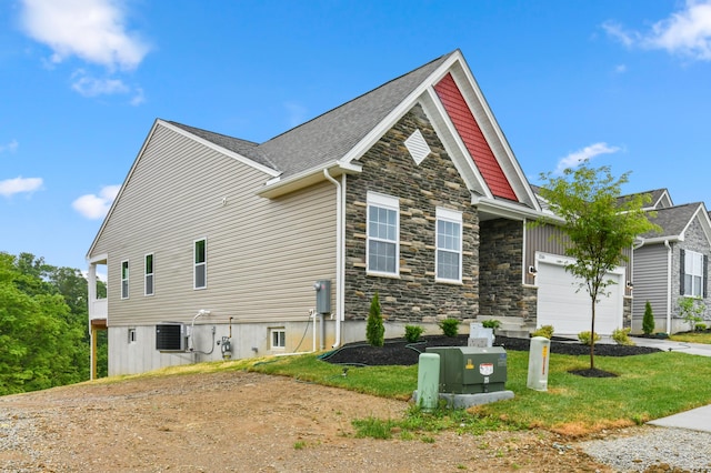 2516 Winners Post Way, Burlington, KY 41005 - view of home's exterior with stone siding, an attached garage, concrete driveway, and cooling unit