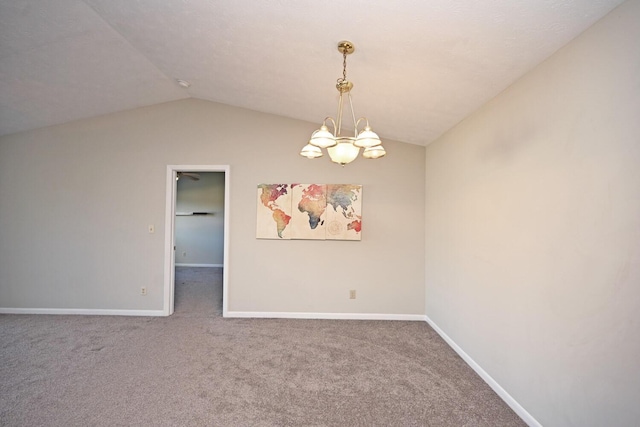 carpeted empty room with lofted ceiling and a notable chandelier