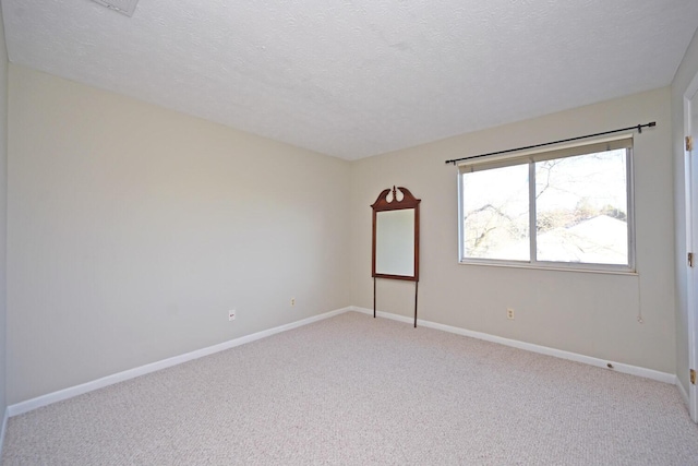 carpeted empty room featuring a textured ceiling