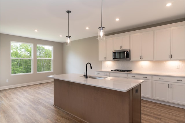 3850 Sherbourne Dr, Independence, KY 41051 - kitchen with stainless steel microwave, a sink, light wood-type flooring, tasteful backsplash, and gas cooktop