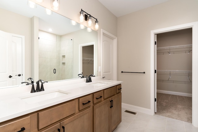 3850 Sherbourne Dr, Independence, KY 41051 - full bathroom featuring a stall shower, tile patterned floors, double vanity, a walk in closet, and baseboards
